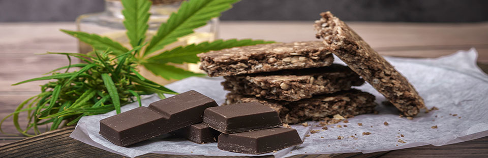Cannabis leaf pictured with a variety of edible cannabis products.
